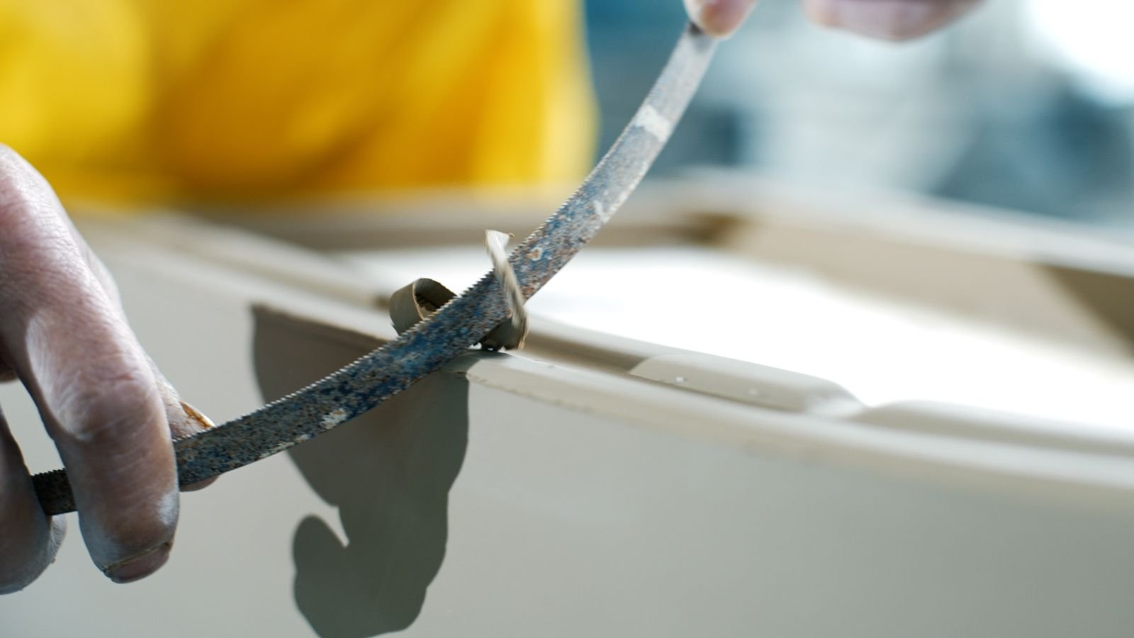 Hand-fettling the seam on a cast ceramic toilet body