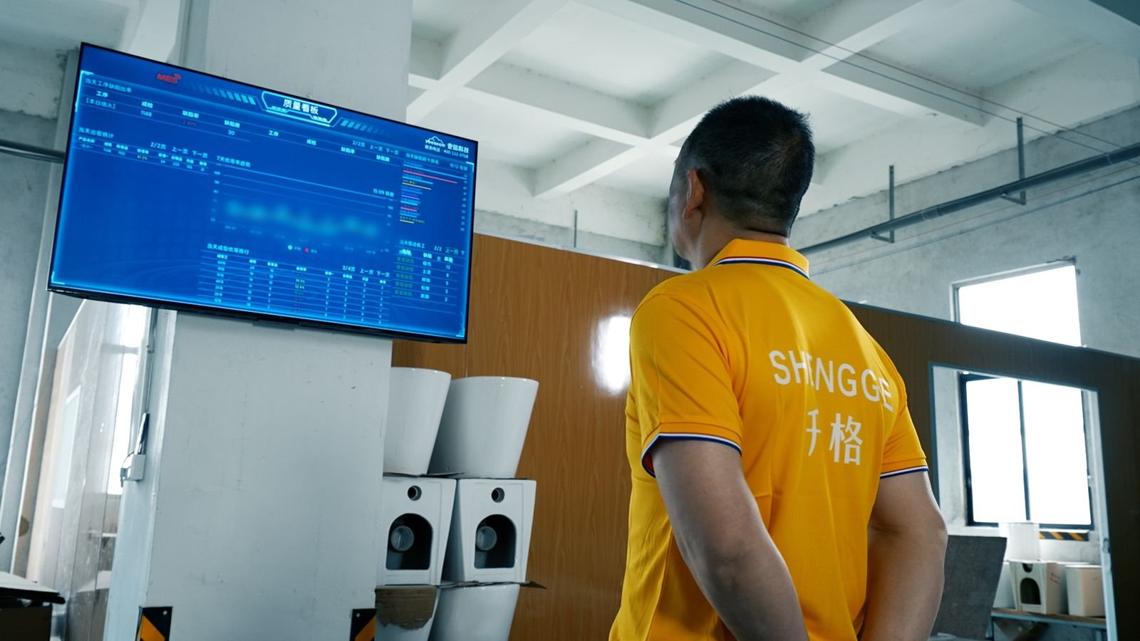 Worker reading the live quality board on the factory floor